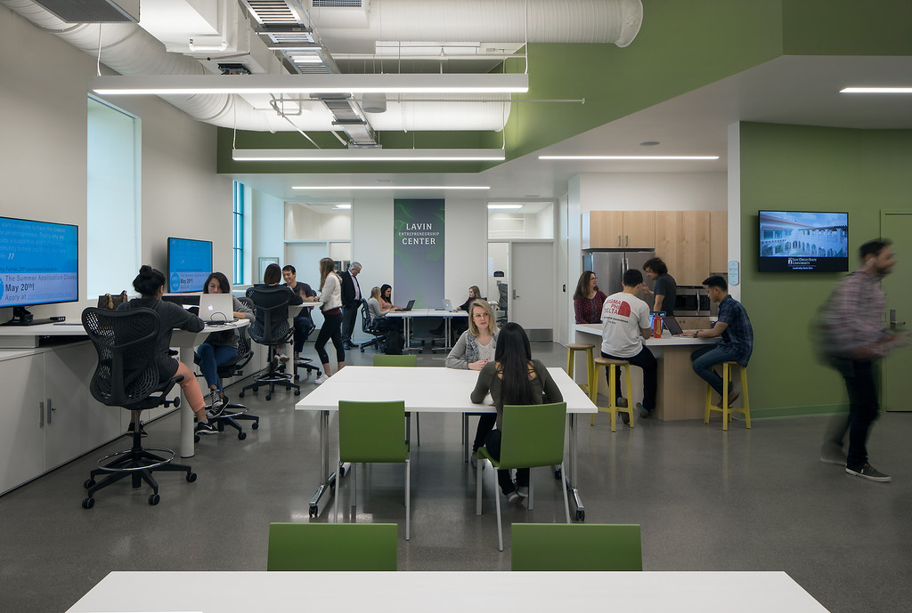 Students studying in a lab with green chairs